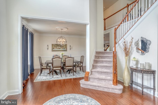 interior space with a notable chandelier, hardwood / wood-style flooring, and ornamental molding