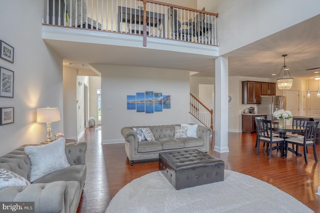 living room featuring a high ceiling and dark wood-type flooring