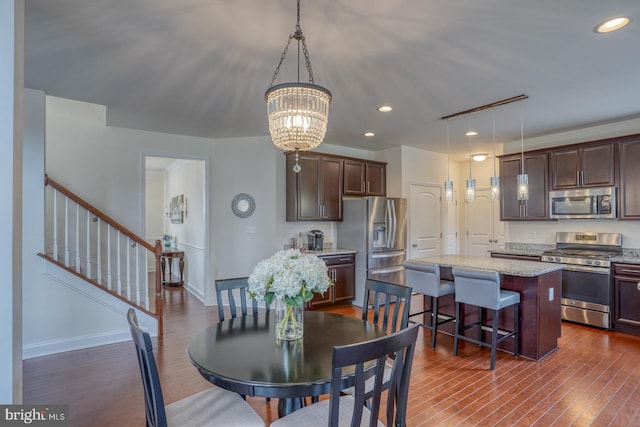 dining space featuring a notable chandelier and dark hardwood / wood-style floors