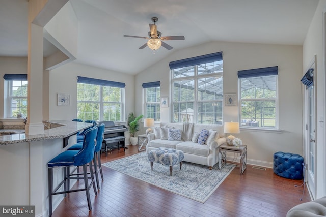 living room with ceiling fan, vaulted ceiling, and dark hardwood / wood-style flooring