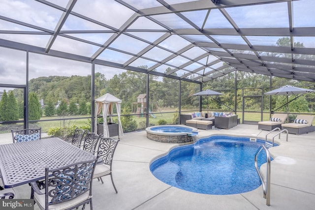 view of pool with a patio, glass enclosure, an outdoor living space, and an in ground hot tub