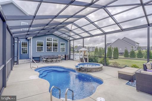 view of swimming pool featuring a lanai, a patio, and an in ground hot tub