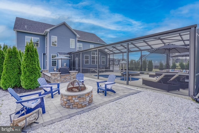 view of patio featuring glass enclosure and an outdoor fire pit