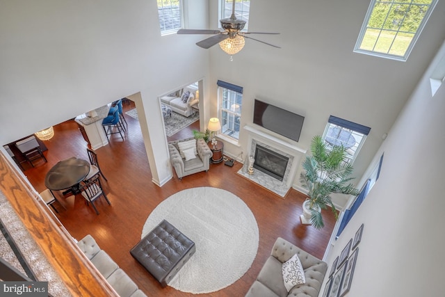 living room featuring ceiling fan, a towering ceiling, and a wealth of natural light