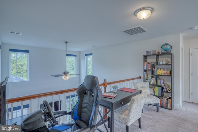 carpeted office space with ceiling fan and a wealth of natural light