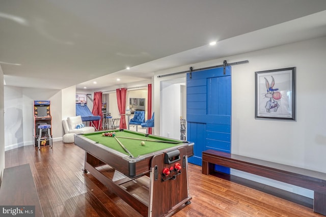 recreation room with billiards, hardwood / wood-style floors, and a barn door