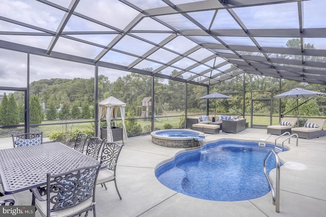 view of pool featuring a patio, glass enclosure, an in ground hot tub, and an outdoor living space