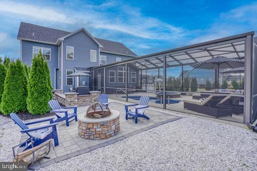 view of patio / terrace with a fire pit, a pool, and a lanai