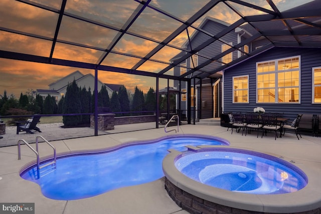 pool at dusk with a patio, an in ground hot tub, and a lanai