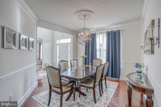 dining area with an inviting chandelier, dark hardwood / wood-style floors, and crown molding