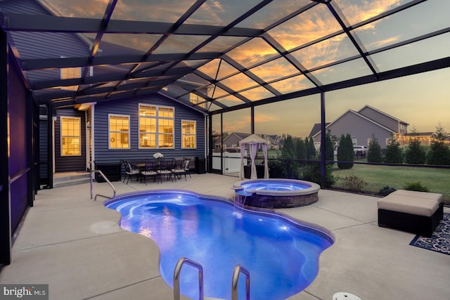 pool at dusk with a lanai, an in ground hot tub, and a patio