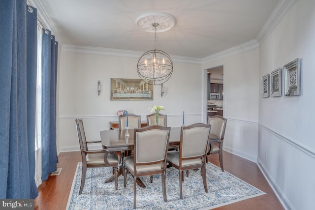 dining room featuring a notable chandelier, dark hardwood / wood-style floors, and ornamental molding