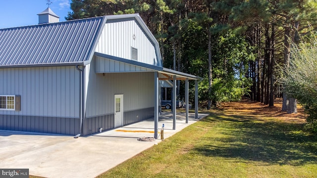 view of side of property featuring a patio and a lawn