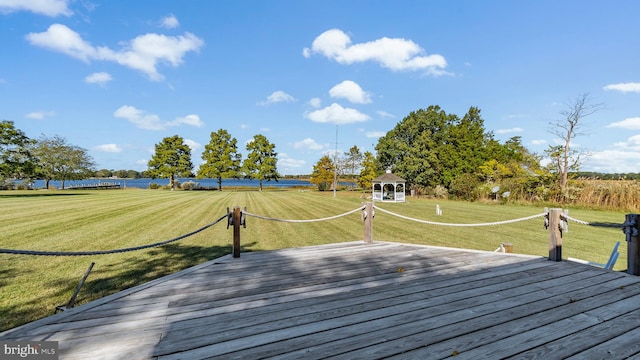 deck featuring a gazebo, a lawn, and a water view