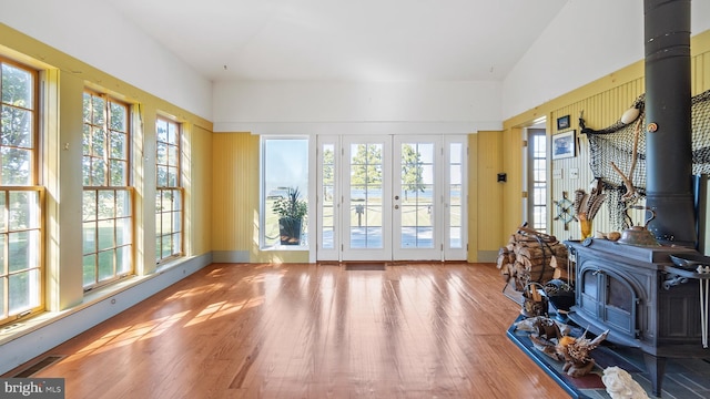 interior space featuring french doors, vaulted ceiling, and a wood stove