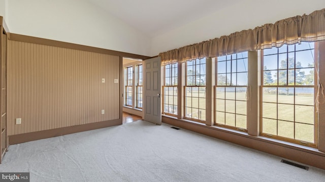 unfurnished room with lofted ceiling and light colored carpet