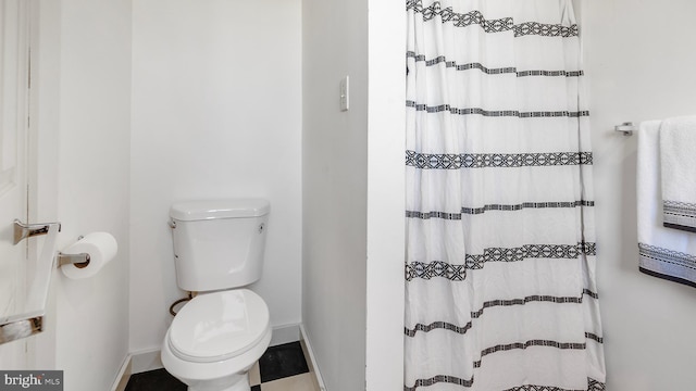 bathroom with toilet and a shower with shower curtain