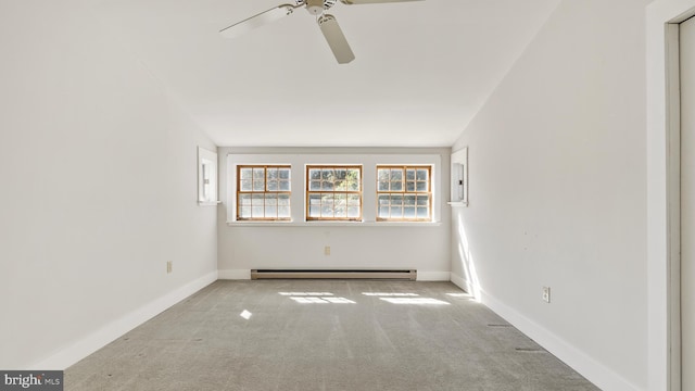 carpeted spare room featuring a baseboard heating unit and ceiling fan