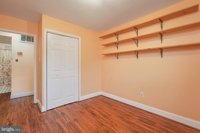 unfurnished bedroom with a closet and dark wood-type flooring