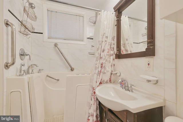 bathroom with a shower with shower curtain, tile walls, and vanity