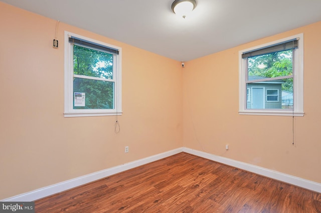 empty room with hardwood / wood-style flooring and a healthy amount of sunlight