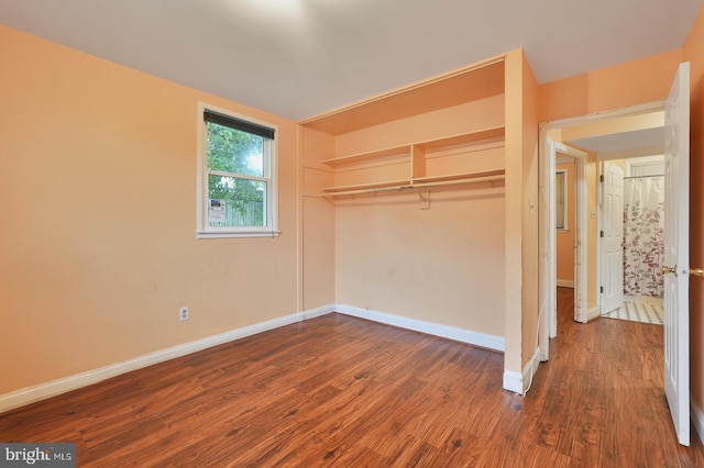 unfurnished bedroom featuring a closet and dark hardwood / wood-style floors