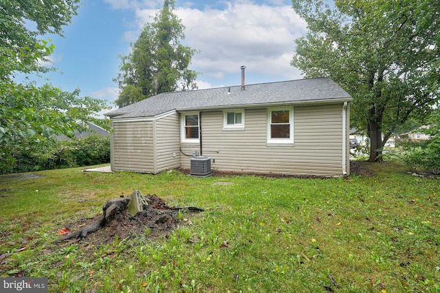 back of property featuring central AC unit and a yard