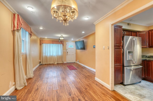 interior space with ornamental molding, an inviting chandelier, and light hardwood / wood-style flooring