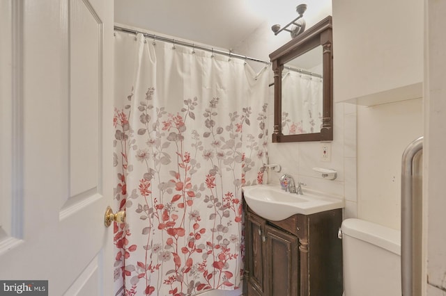 bathroom with curtained shower, decorative backsplash, vanity, and toilet