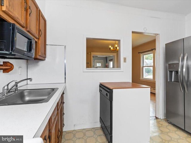 kitchen featuring black appliances, sink, and a chandelier