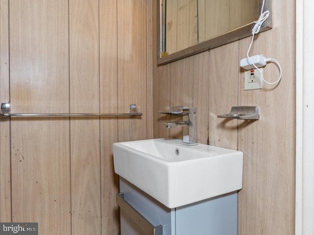 bathroom featuring vanity and wood walls