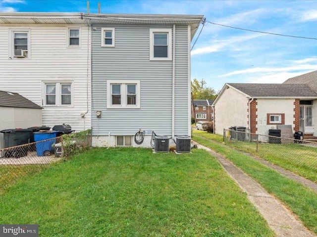 back of house featuring a lawn, cooling unit, and central AC