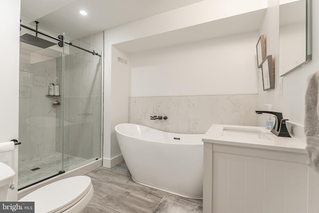 full bathroom with wood-type flooring, vanity, toilet, and separate shower and tub