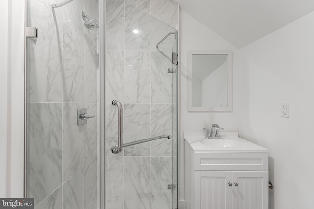 bathroom with vanity, vaulted ceiling, and an enclosed shower