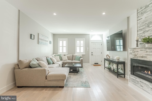 living room featuring light wood-type flooring and a fireplace