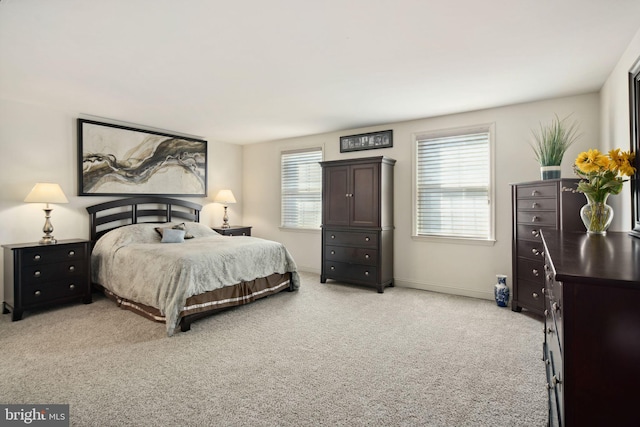 bedroom with light carpet and multiple windows