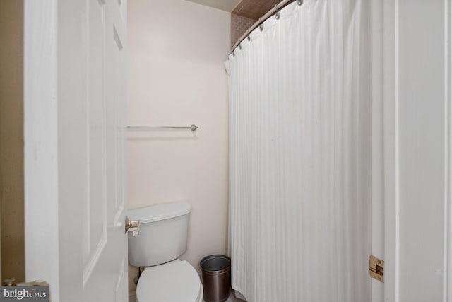 bathroom featuring walk in shower and toilet