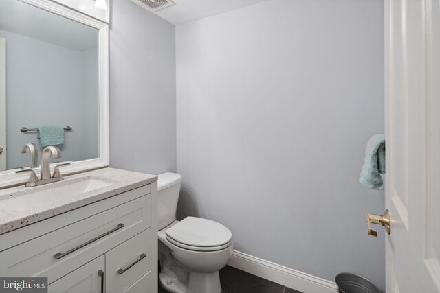 bathroom with vanity, toilet, and tile patterned floors