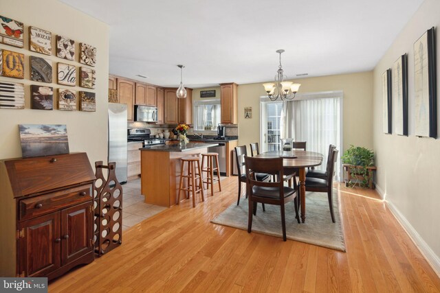 dining room with a notable chandelier and light wood-type flooring