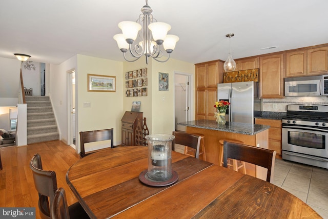 dining room with an inviting chandelier and light hardwood / wood-style floors