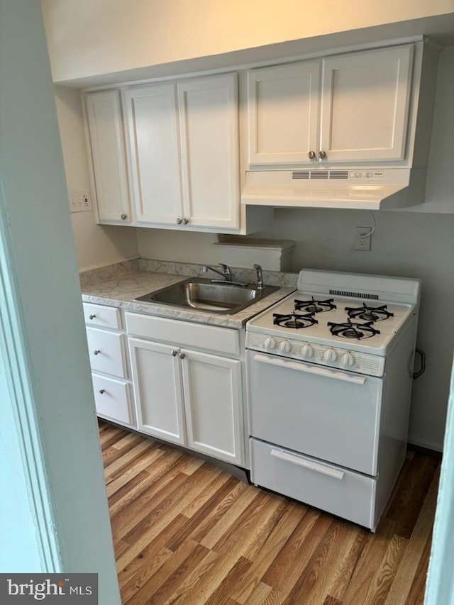 kitchen with sink, extractor fan, white cabinetry, white range oven, and light wood-type flooring