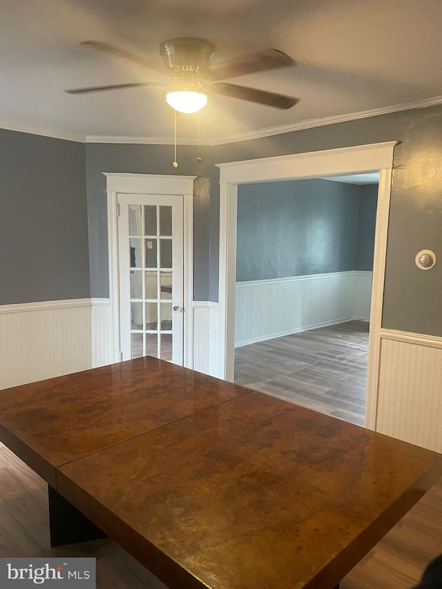 unfurnished dining area with dark hardwood / wood-style floors, ceiling fan, and crown molding