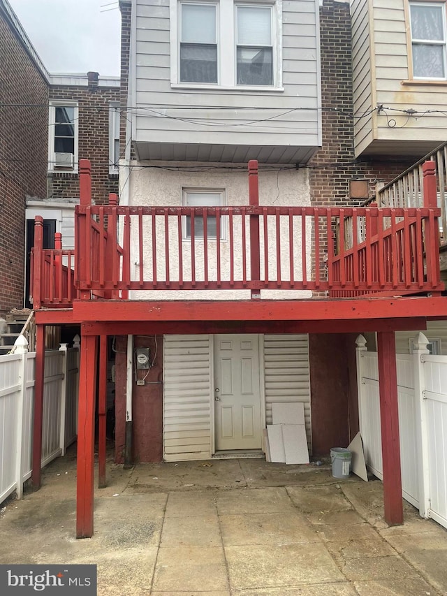 rear view of property featuring a patio and a wooden deck