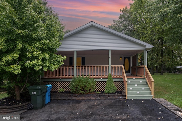 view of front of property featuring a porch and a yard