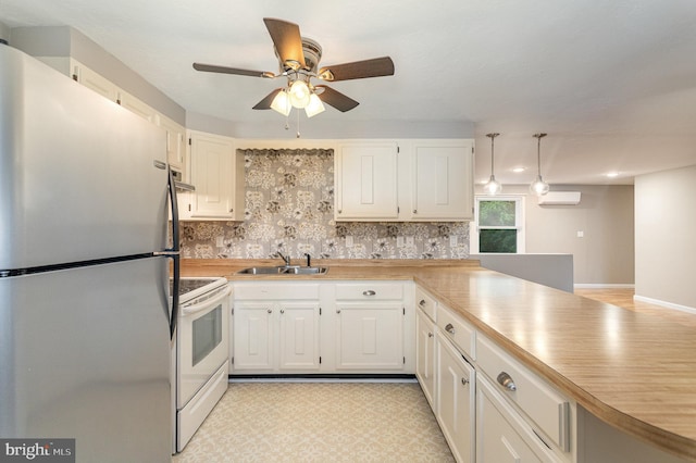 kitchen featuring sink, kitchen peninsula, stainless steel fridge, white range with electric stovetop, and white cabinets