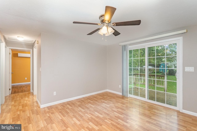 spare room featuring ceiling fan, an AC wall unit, and light hardwood / wood-style flooring