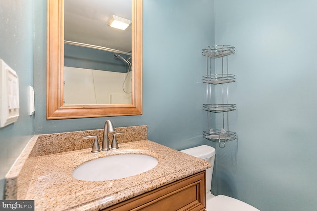 bathroom with vanity, toilet, and a shower