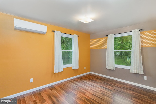 unfurnished room with hardwood / wood-style floors and a wall mounted air conditioner