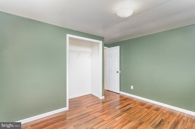 unfurnished bedroom with a closet and wood-type flooring