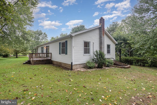 view of side of home featuring a yard and a deck